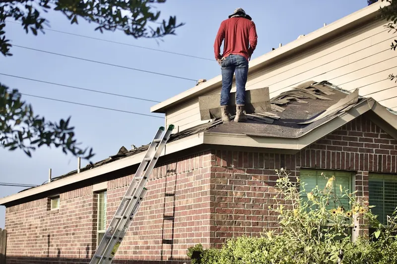 Professional roofer working on a residential roof in Talladega